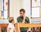 Christian dad tells his son Bible stories about Jesus sitting in kirk. Faith, religious education, modern church, father