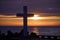 Christian Holy cross early in the morning at sunrise. The large cross stands on the edge of a breakwater on the sea