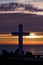 Christian Holy cross early in the morning at sunrise. The large cross stands on the edge of a breakwater on the sea