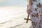 Christian lady girl holding a holy cross in her hand and standing on the beach