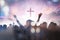 Christian people group raise hands up worship God Jesus Christ together on cross over cloudy sky background