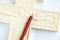 Christian plaster cross and church candle on a white background close-up, love of god