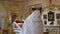 A Christian priest in festive attire with glasses prays.