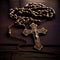 Christian rosary with metal crucifix on wooden background