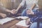 Christian small group holding hands and praying together around a wooden table