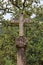 Christian stone cross amidst trees and vegetation