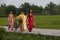 Christian Vietnamese women wearing Ao Dai while walking to the church on a country road