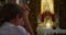 Christian woman prays on her knees in temple of the Lord. Close-up religious girl in church worshiping God.