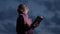 A Christian woman reads a bible, raises her head up and looks at the sky