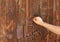 Christian woman`s hand knocking on an old wooden door. Seek and find God and Jesus Christ.