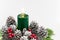 Christmas arrangement with a candle and pine cones on greenery