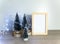 Christmas arrangement, little fir tree, blank photo frame, lights garland, festive composition with copy space for artwork