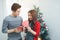 Christmas Asian Couple. A handsome man giving her girlfriend/wife a gift at home celebrating New Year People