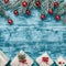 Christmas azure background with handmade gifts and fir branches with red globes. Space for text. Top view