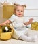 Christmas baby child toddler near gold christmas presents and ba