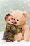 Christmas baby in pajamas holding teddy bear