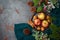 Christmas background with apples, walnuts and warm sweater on stone tabletop. Holidays greeting card concept