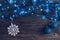 Christmas background with blue garland and lights. Christmas balls and snowflake on wooden background.