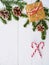 Christmas background with candy cane, gift, cones and fir branches over white wooden table
