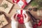 Christmas Background. Female Hands Tying A Red Bow. Woman Packing Christmas Gifts. Holiday Concept. Top View, Flat Lay, Advent