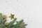 Christmas background with fir branch, golden sparkling balls and a star on a white background.