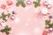 Christmas background with fir branches, lights, red giftboxes, pink decorations, hot drink with snow falling