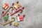 Christmas background, gingerbread cookies, candy cane and Christmas-tree decorations on a gray concrete background. Top view, flat