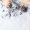 Christmas background with glass xmas bauble , frozen branches and cones on snow with snowfall and bokeh,