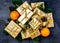 Christmas background. Golden gift boxes and Christmas decoration - oranges, Christmas tree branches and cones on slate