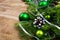 Christmas background with green baubles and snow decorated pine