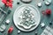 Christmas background in grey, red and white plate on table. Geometric flat lay with Xmas decorations. Xmas tree shape