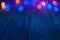 Christmas background in mostly blue tones with colored bokeh over a blurred wooden table. Copy space