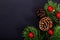 Christmas background pine leaves, pine corn and glitter ball on black background