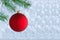 Christmas background - red ball and branch of spruce tree. Copy space.
