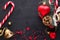 Christmas background: red gift box with a Christmas toy in the shape of a heart, a golden bell , fir branches , christmas candy,