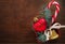 Christmas background: red gift box with a Christmas toy in the shape of a heart, a golden bell , fir branches and christmas candy