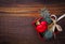 Christmas background: red gift box with a Christmas toy in the shape of a heart, a golden bell and fir branches. Top view. Flat