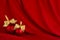 Christmas background in rich luxury style - two shiny red balls, gold ribbon on scarlet silk curtain with smooth creases.
