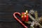 Christmas background, Santa, candy cane, spruce branch with cones in the snow and gift on dark wooden background