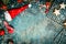 Christmas background with Santa hat, snow , red winter decoration and star cookies, top view