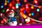 Christmas background with a snowman and a garland. Festive background with lights for congratulations.
