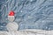 Christmas Background, Snowman wearing red Santa hat in winter with snow, paper cut made of crumpled paper