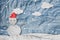 Christmas Background, Snowman wearing red Santa hat in winter with white clouds snow, paper cut made of crumpled paper