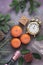 Christmas background, tangerines, gifts, champagne, alarm clock are covered with snow. Purple background, top view.