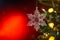 Christmas and background.Toy in the form of a transparent star on a Christmas tree, background for a card, dark red bokeh