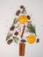 Christmas background on a white background, vertical layout. Christmas tree made of pine cones, twigs, dried oranges