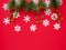 Christmas background with white snowflakes, spruce branch, caramel on red backdrop. Winter holiday concept. copy space