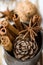 Christmas Baking Ingredients Cinnamon Sticks Anise Star Walnuts Cloves Pine Cone in Vintage Jug on Wood Background