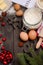 Christmas baking ingredients - cookies cutters, spices, butter, eggs and flour on dark wooden background