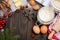 Christmas baking ingredients - cookies cutters, spices, butter, eggs and flour on dark wooden background